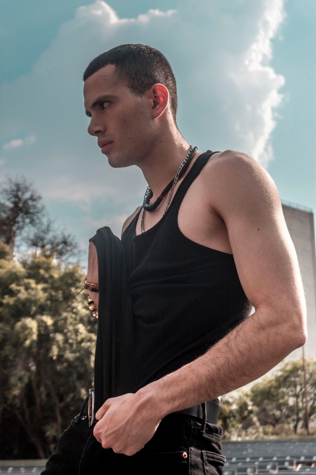 Black tank top, lean build, outdoor profile